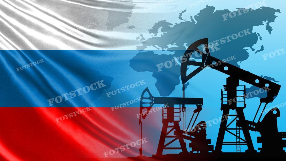 На фотографии силуэты нефтяных вышек на фоне флага России, сочетающиеся с контурами географической карты мира. Это изображение может использоваться для символизации важности нефтяной промышленности в России и ее роли в мировой экономике.